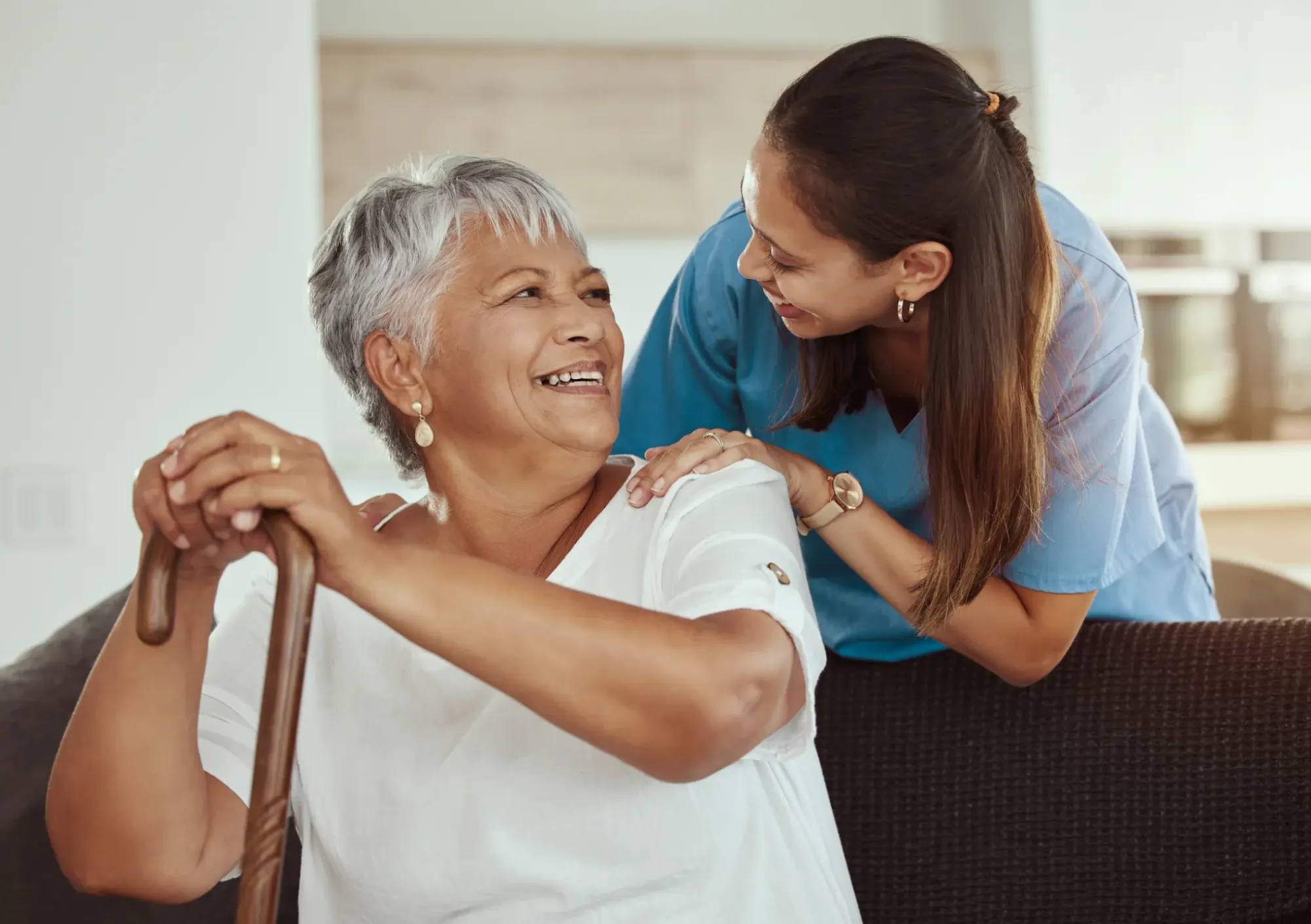 Nurse, supporting an older woman with cane.